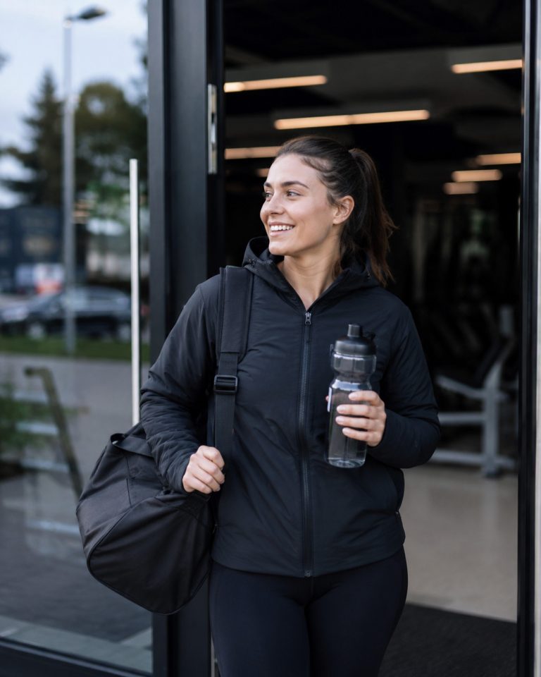 person leaving gym wearing warm dry sports clothes after workout, fresh air, healthy recovery concept